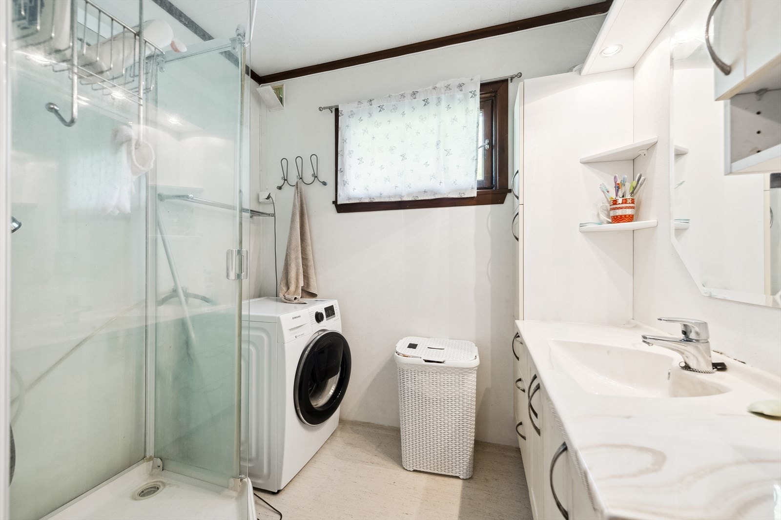 Badet er videre utstyrt med dusjkabinett, servantinnredning med under-, side- og overskap, samt opplegg og plass til vaskemaskin. Våtrommet må oppgraderes for å tåle normal bruk etter dagens krav. Galleribilde