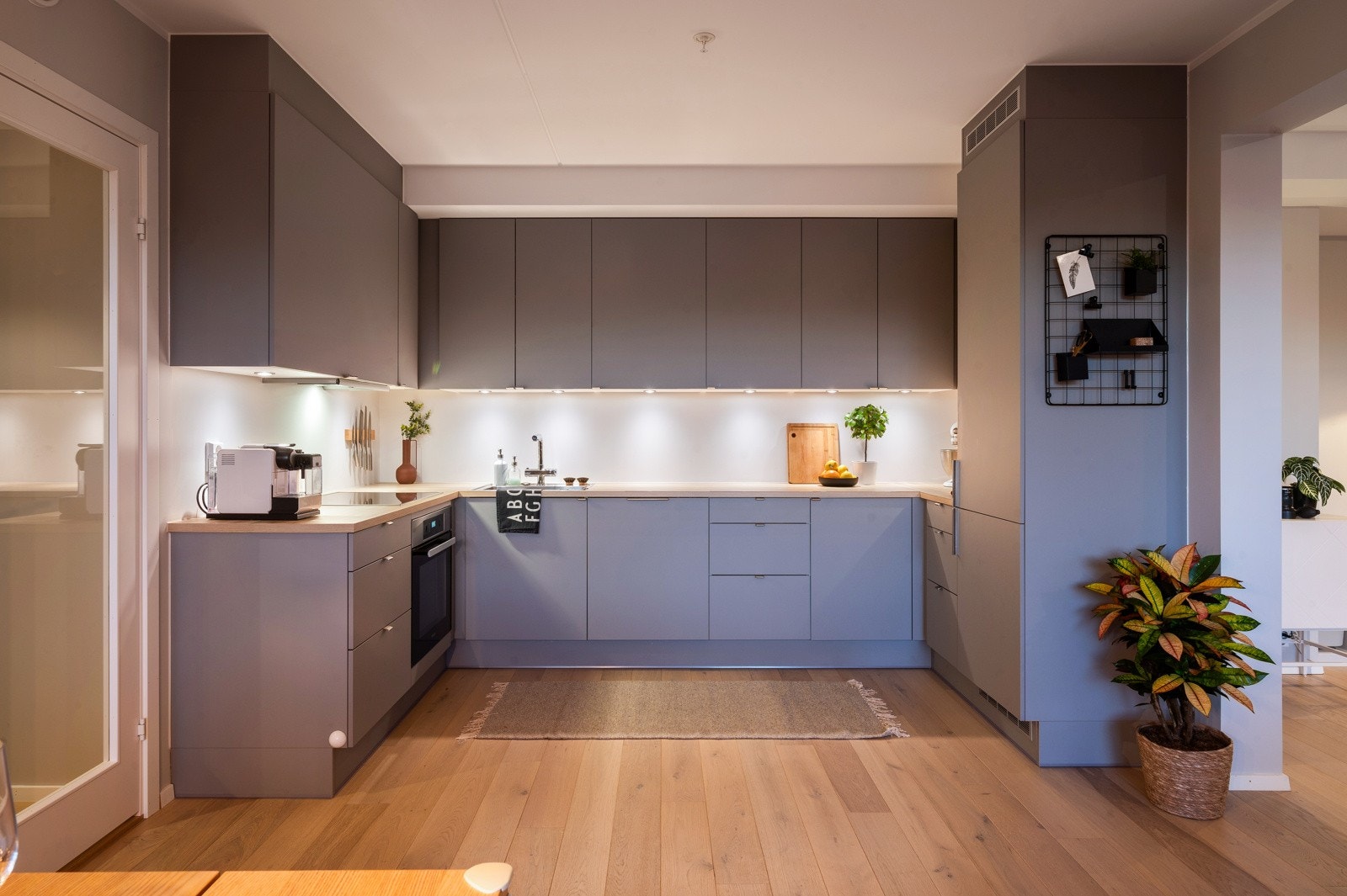 Leiligheten har et moderne og stilrent kjøkken med glatte skapfronter og laminat benkeplater som gir et rent og tidløst uttrykk Galleribilde