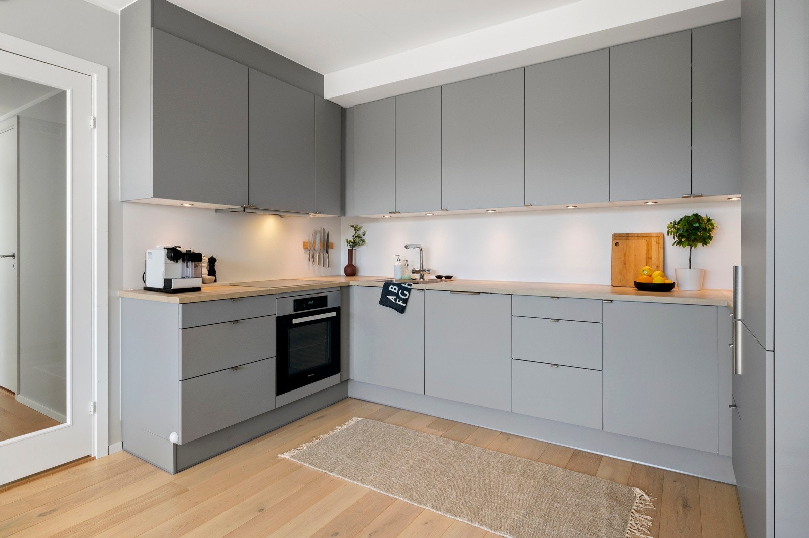 Kjøkkenet er godt utstyrt med integrerte høykvalitets hvitevarer fra Miele, som oppvaskmaskin, stekeovn, induksjonstopp og kombinert kjøl-/fryseskap, noe som gir en sømløs og praktisk hverdag Galleribilde