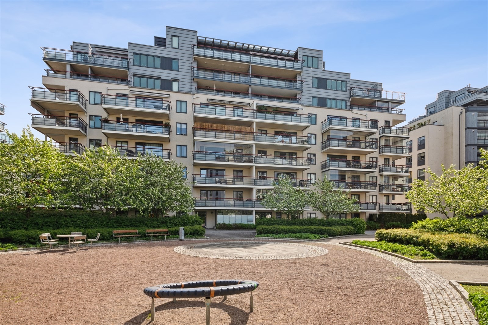 Eiendommen står på en pent opparbeidet tomt som preges av grøntarealer og asfalterte gangveier. Galleribilde