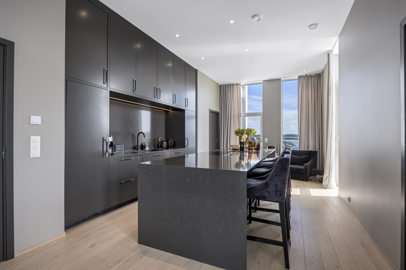 Kjøkken med tidsriktig og delikat innredning i mørk utførelse fra Grindberg trevare med matchende heldekkende benkeplate Galleribilde