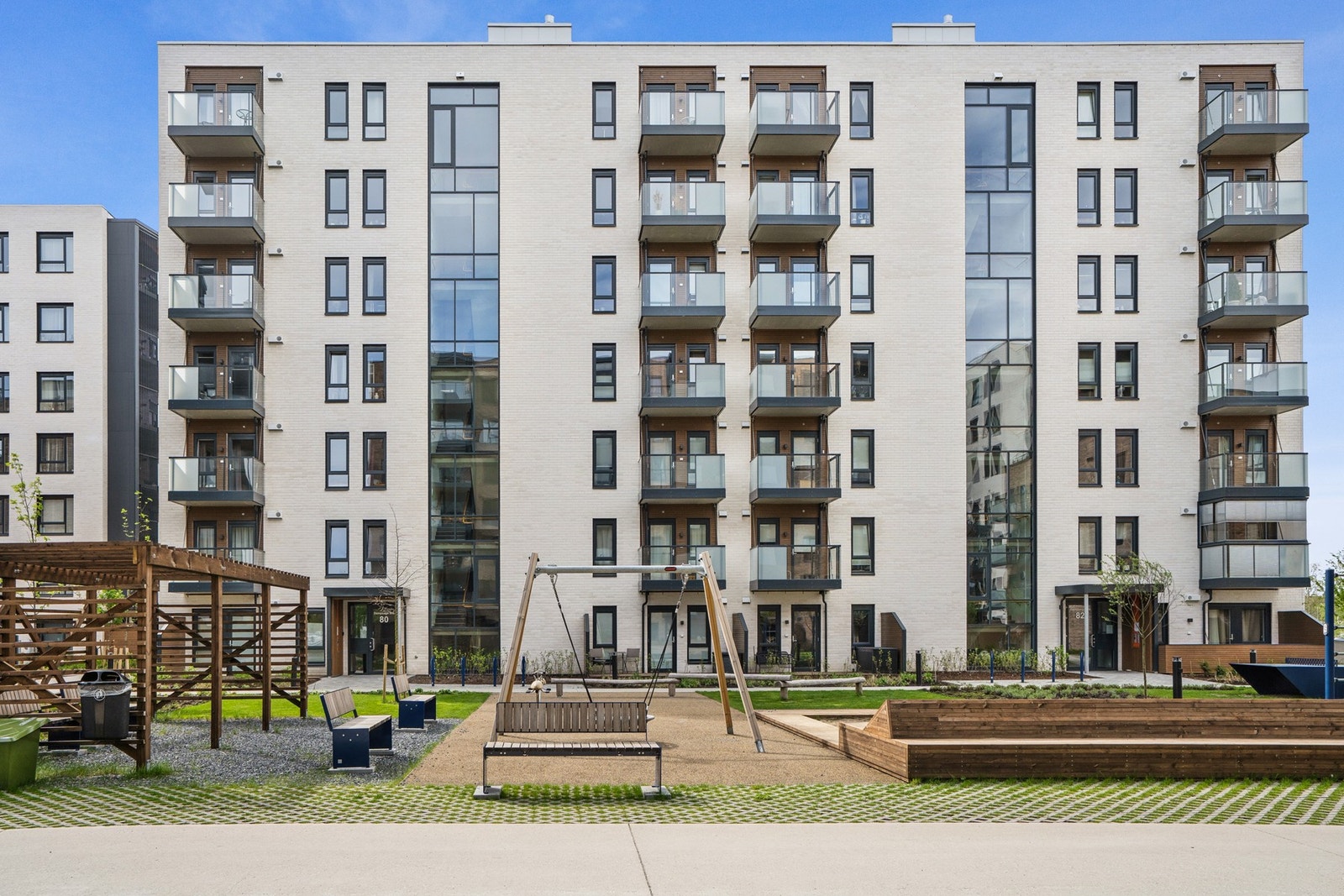 I hjertet av boligområdet finner du et stort fellesareal med lekeplass, benker og pergola Galleribilde