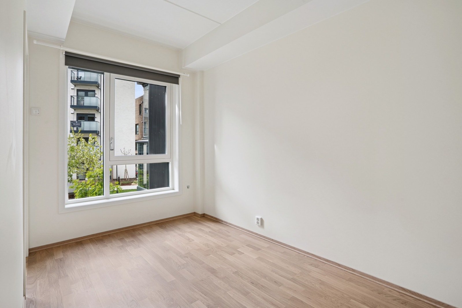 Videre kommer vi inn til et romslig soverom med store vindusflater og utsyn mot grønne omgivelser. Galleribilde