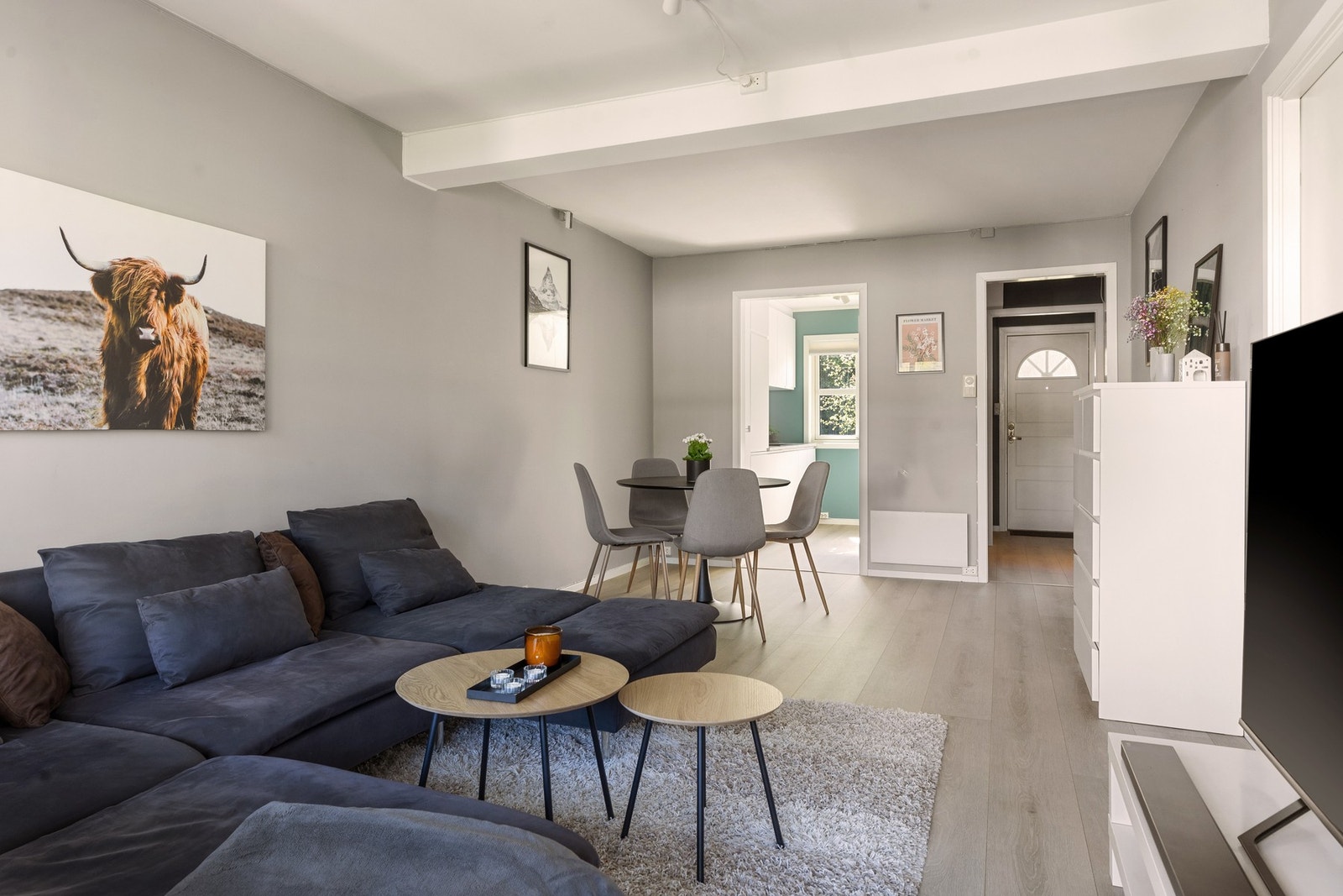 Leiligheten har en praktisk og fin løsning som gir rom for både spisebord og stor sofa med et praktisk kjøkken Galleribilde