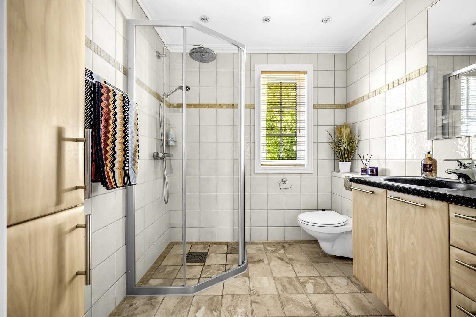 Flislagt baderom med gulvvarme, downlights i himling og regnfallsdusj Galleribilde