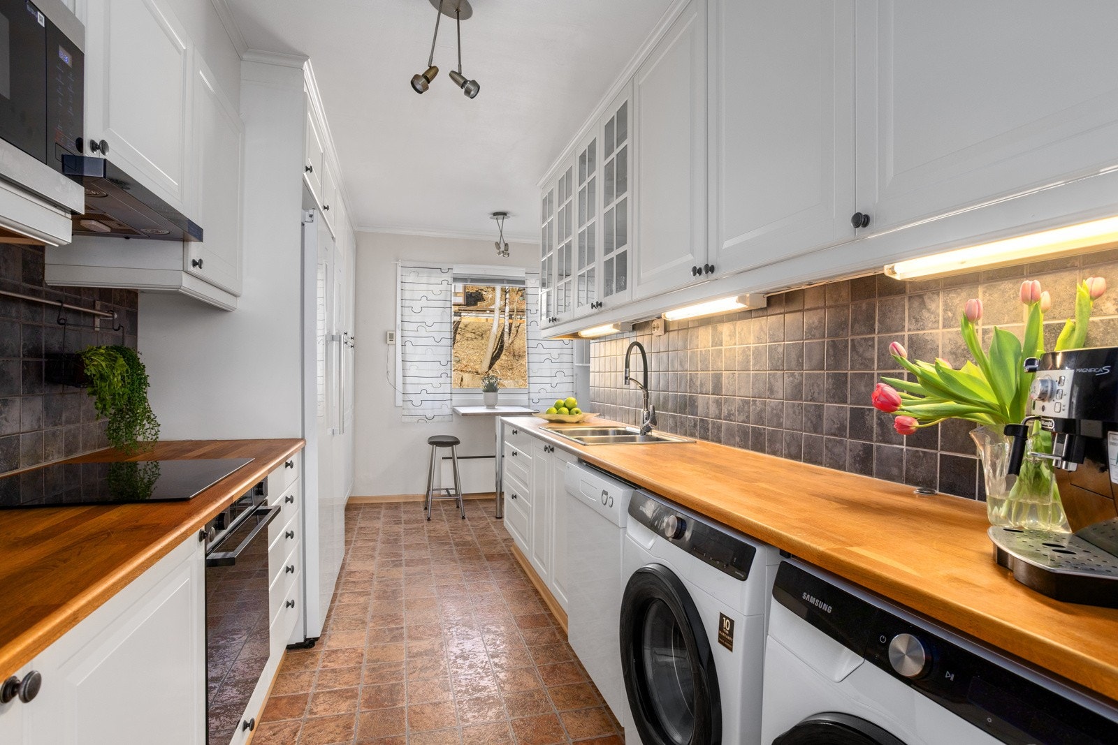 Hvit kjøkkeninnredningen fra 2006 med profilerte fronter. Benkeplate av tre. Nedfelt oppvaskkum med ett-greps kjøkkenarmatur Galleribilde