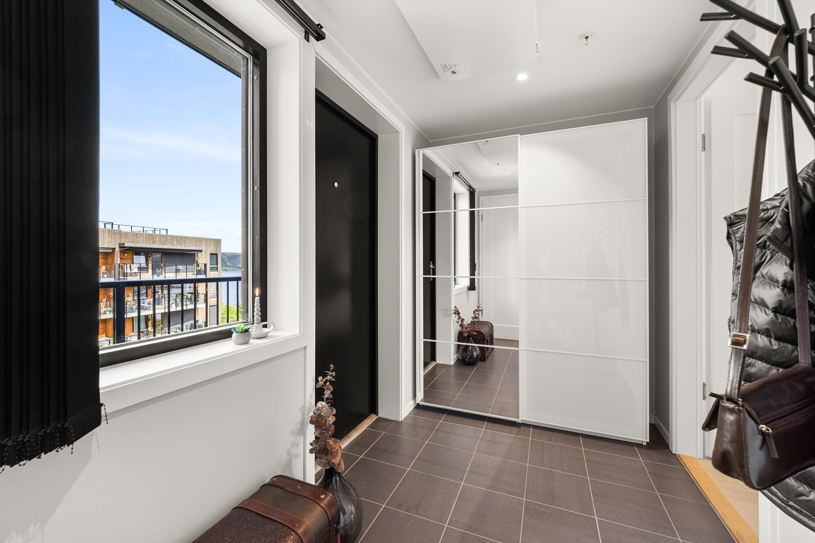 Leiligheten har en romslig flislagt hall med god plass for å henge fra seg Galleribilde