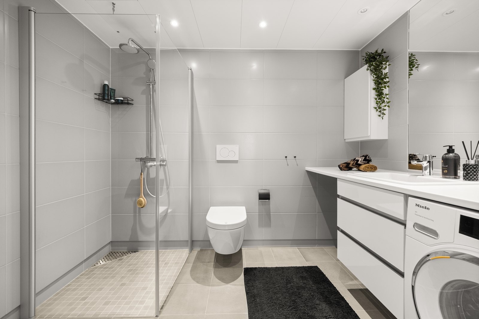 Badet er av god størrelse med langsgående benkeplate med opplegg for vaskemaskin Galleribilde