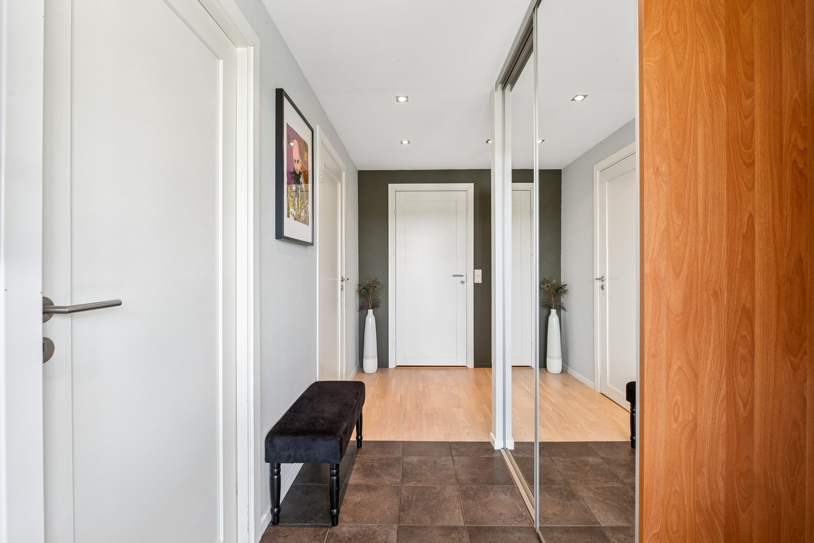 Entreen ønsker deg velkommen med moderne downlights og en innebygd skyvedørsgarderobe med speil. Galleribilde