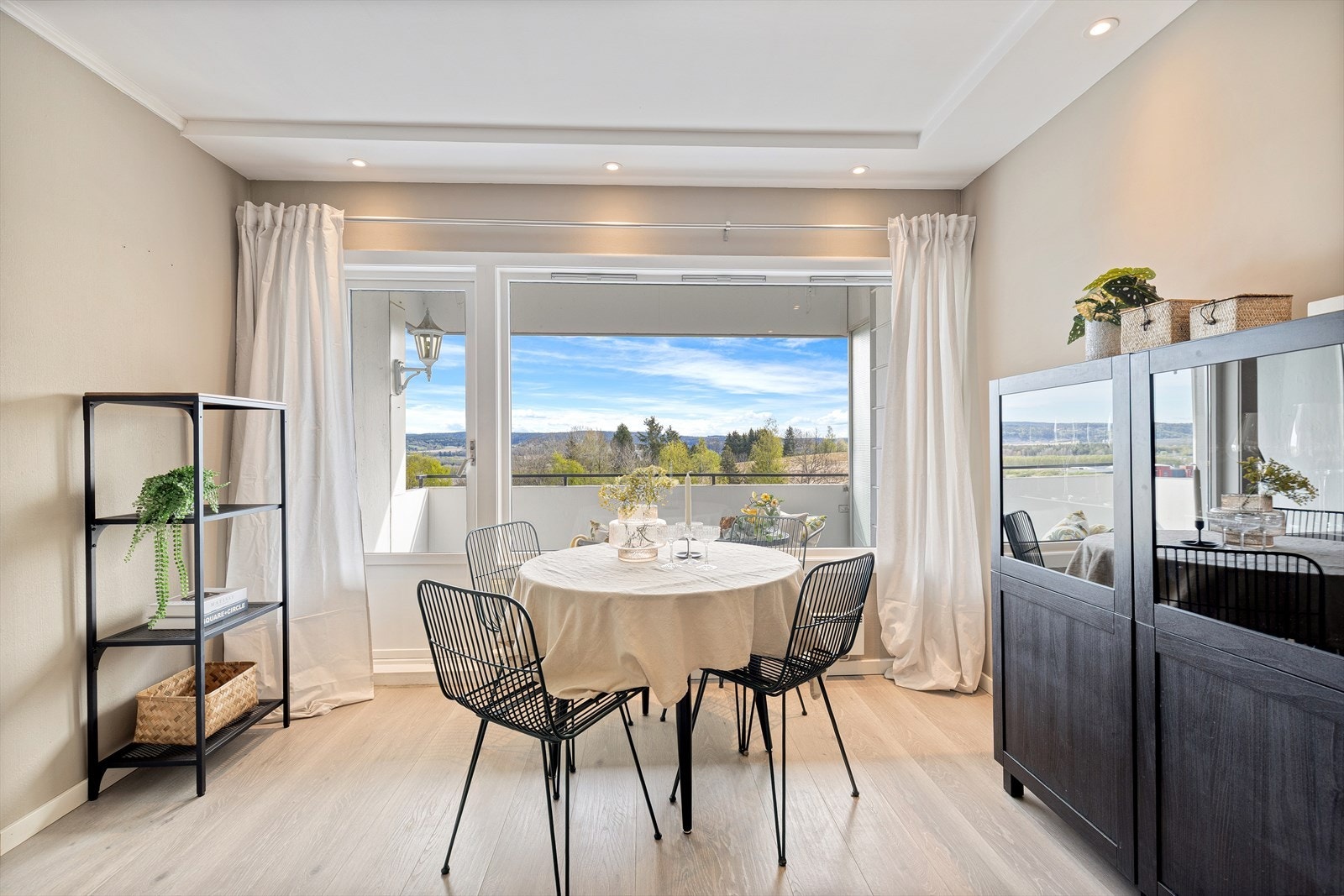 Luftig og lys stue med store gode vindusflater vendt ut mot balkong Galleribilde