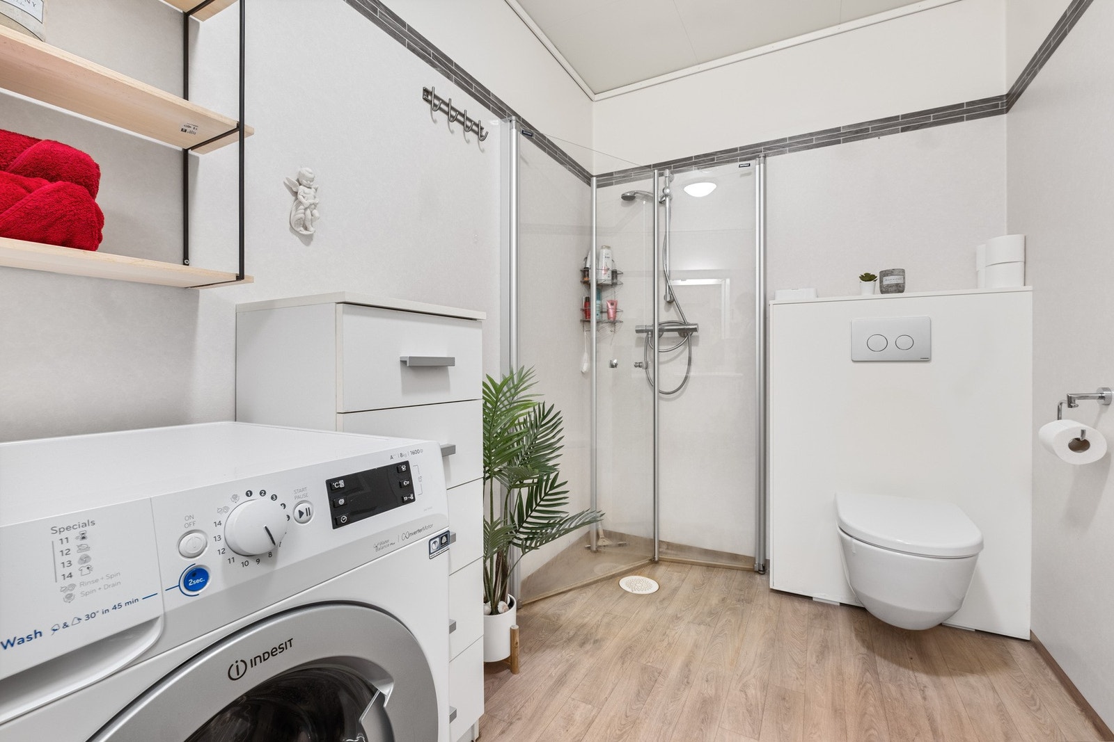 Rommet er utstyrt med vegghengt toalett, servant, dusjnisje og opplegg for vaskemaskin. Galleribilde