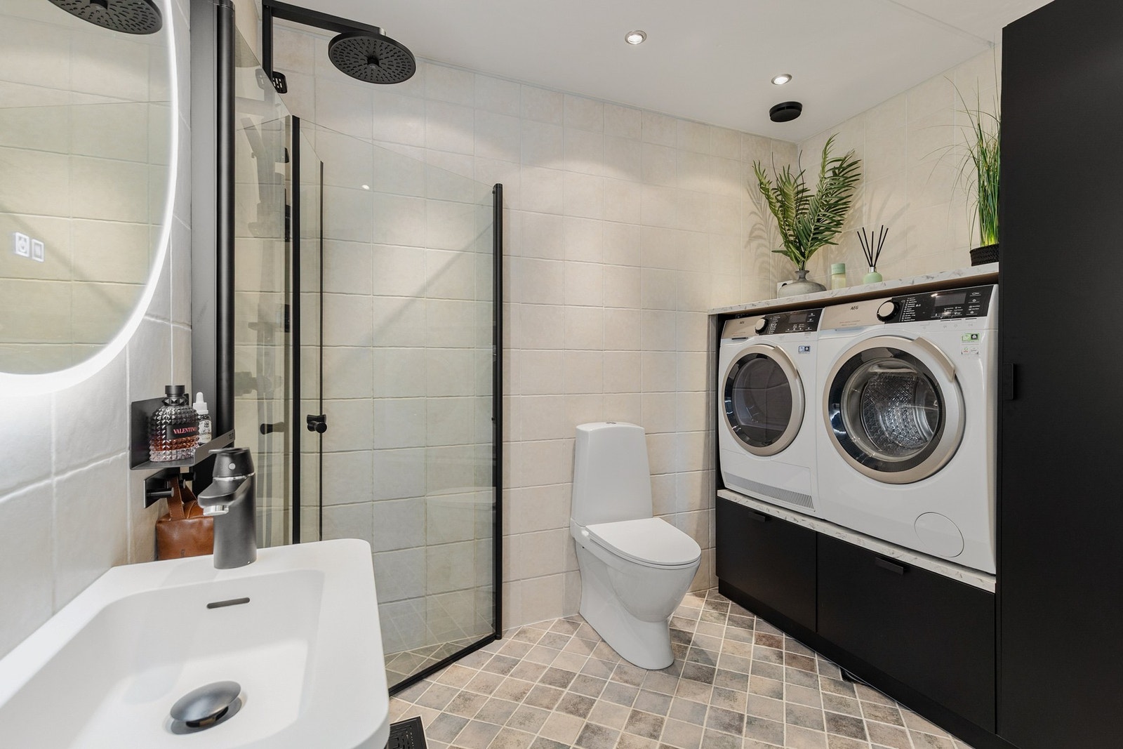 Helfliset bad med gulvstående toalett, dusjhjørne og gulvstående innredning med plass for både vaskemaskin og tørketrommel Galleribilde