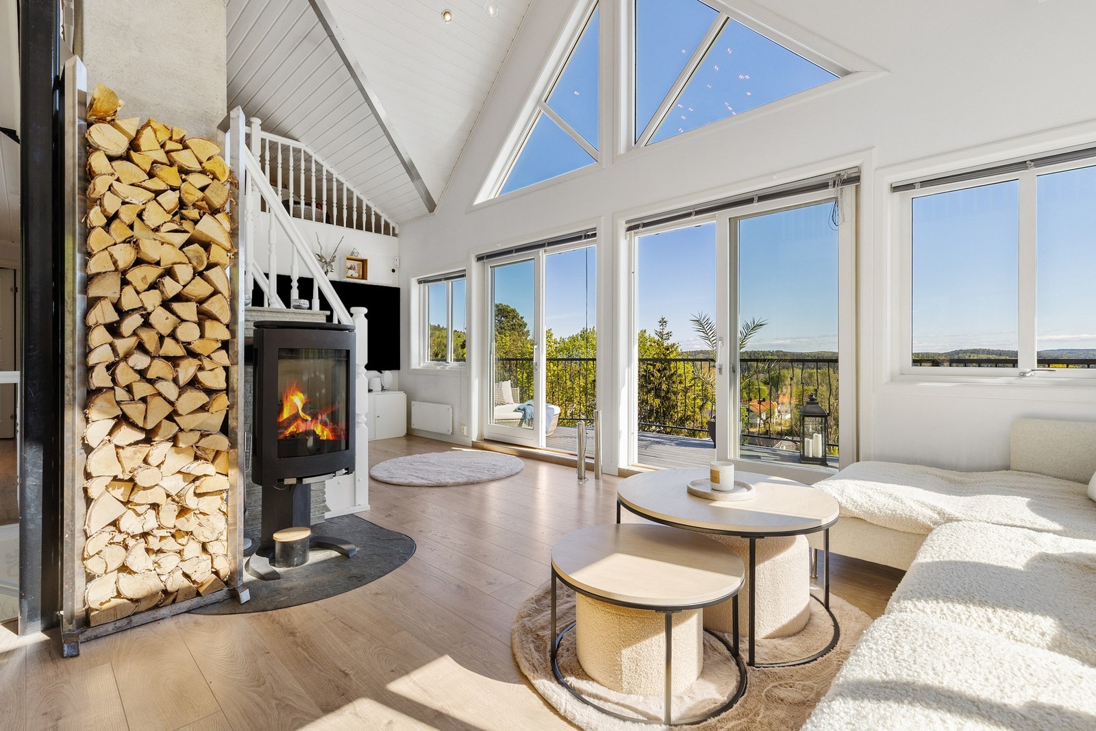 Romslig stue med laminat på gulv, tapetserte vegger og panel i himling med downlights Galleribilde