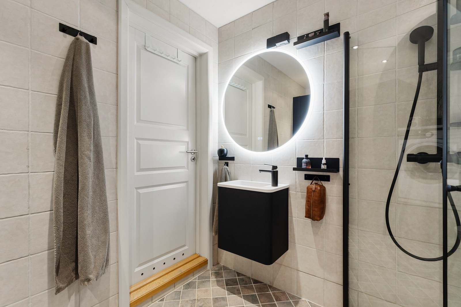 Det er montert en vegghengt servantinnredning med dører og en ovenpåliggende servant med ett-greps armatur. Over servant er det montert speil med integrert lys Galleribilde