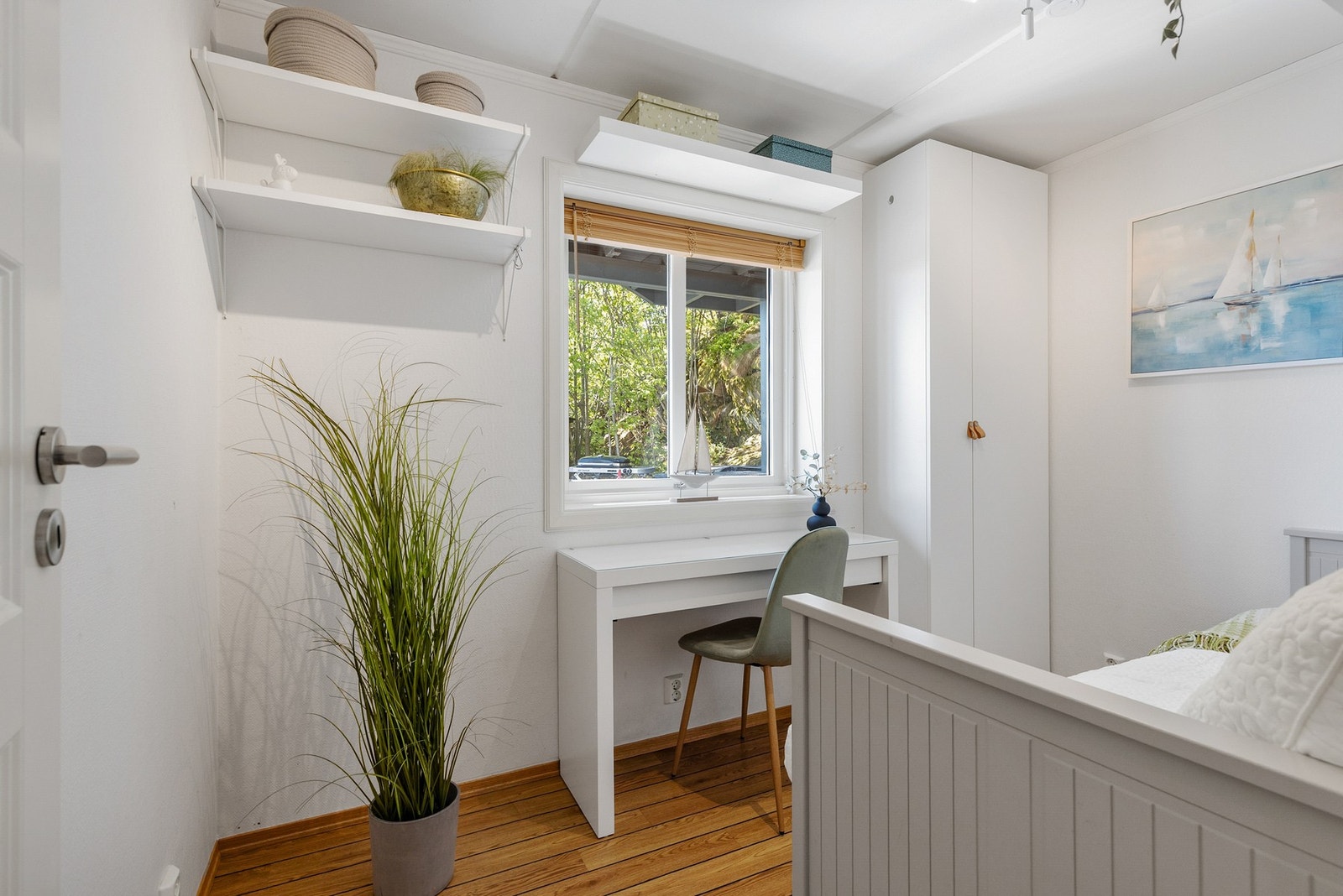 Soverom med gulvbord av tre, malt tapet på vegger og slett flate i himling Galleribilde