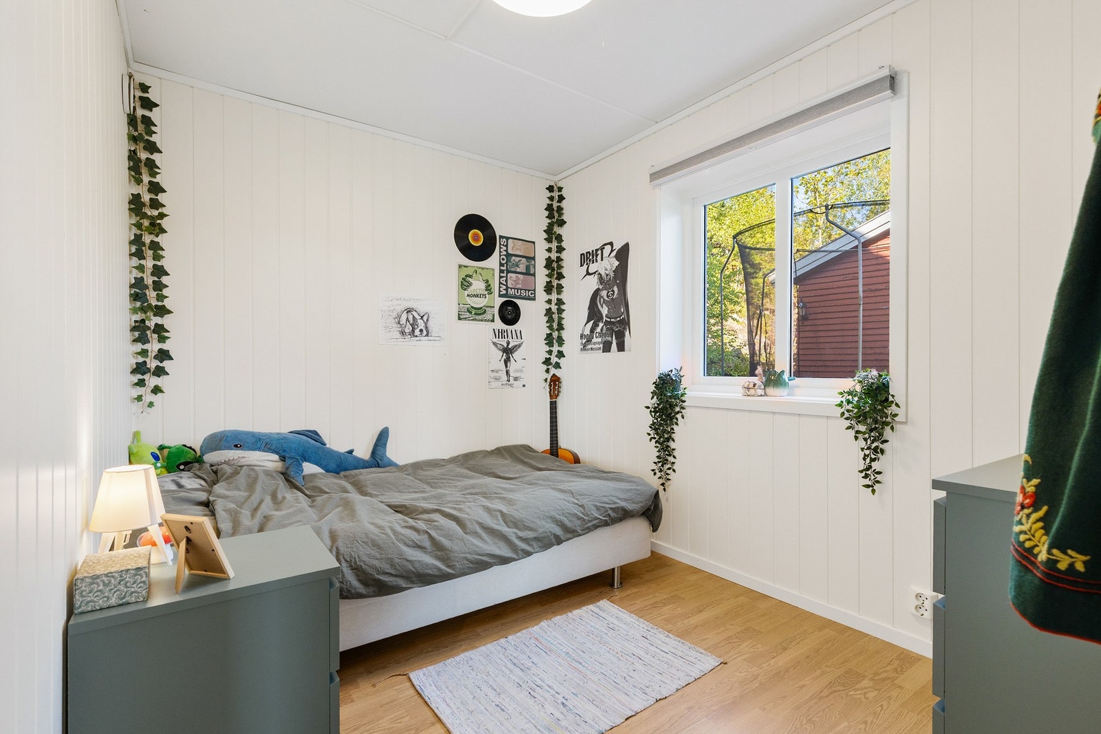 Pent soverom med laminat på gulv, panelplater på vegger og slett flate i himling Galleribilde