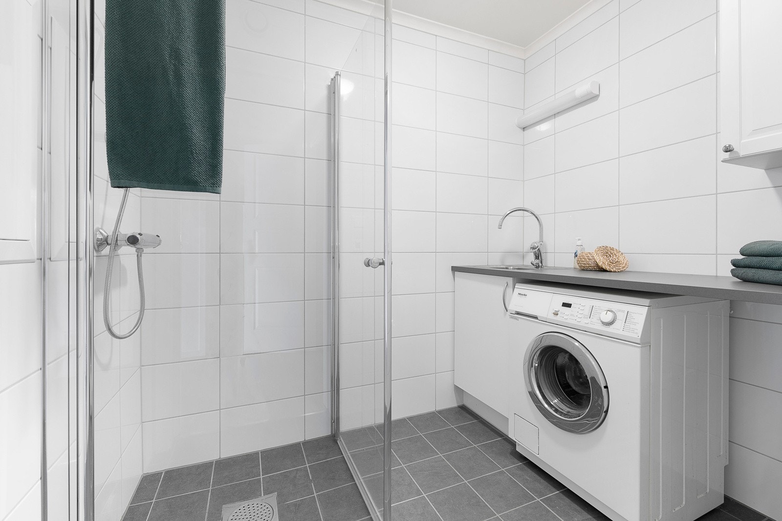 Bad i "gjestefløyen" med dusjnisje, opplegg for vaskemaskin og praktisk benk til klesbrettingen Galleribilde