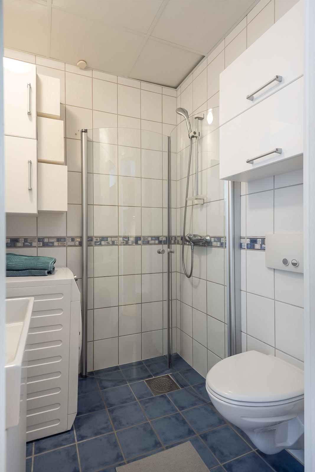 Badet er utstyrt med dusjinnredning, ferdig opplegg for vaskemaskin og behagelig gulvvarme. Galleribilde