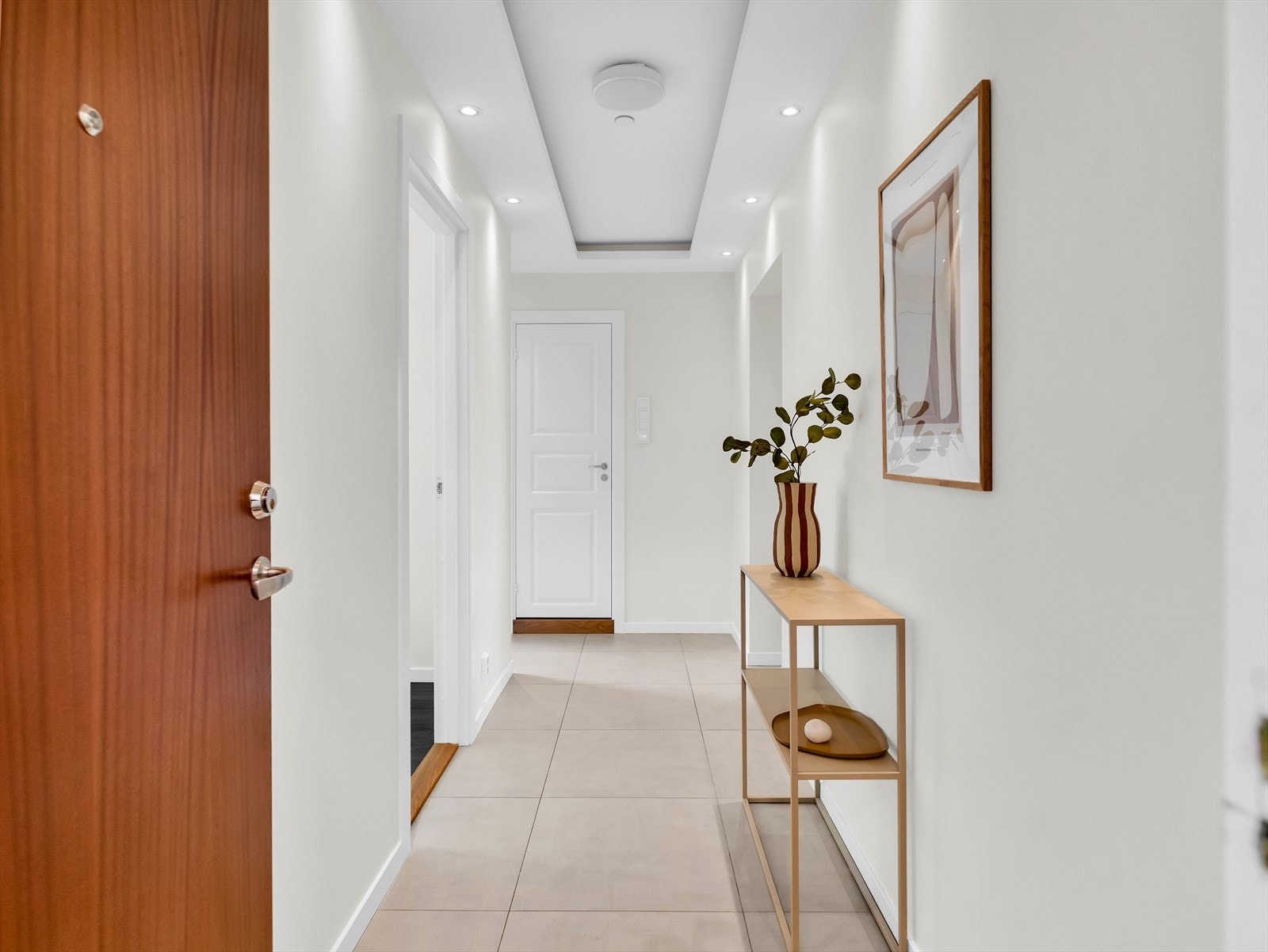 Boligen har en lys og innbydende entré, med plass til å henge fra seg yttertøy og sette fra seg sko. Det er flis på gulv og malt overflate på vegger. Rommet er opplyst med downlights. Porttelefon gjør det enkelt å slippe inn gjester. Galleribilde