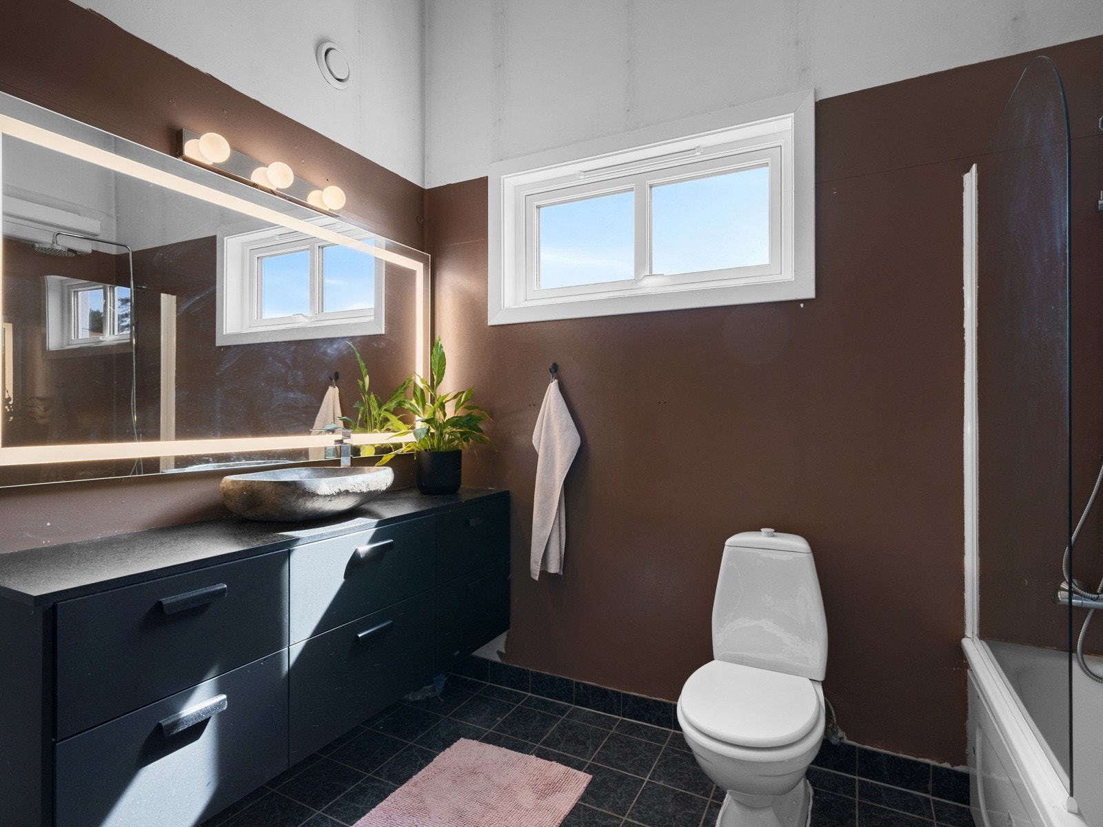 Badet er innredet med toalett, badekar med dusj, nyere baderomsinnredning fra Designa og opplegg for vaskemaskin Galleribilde