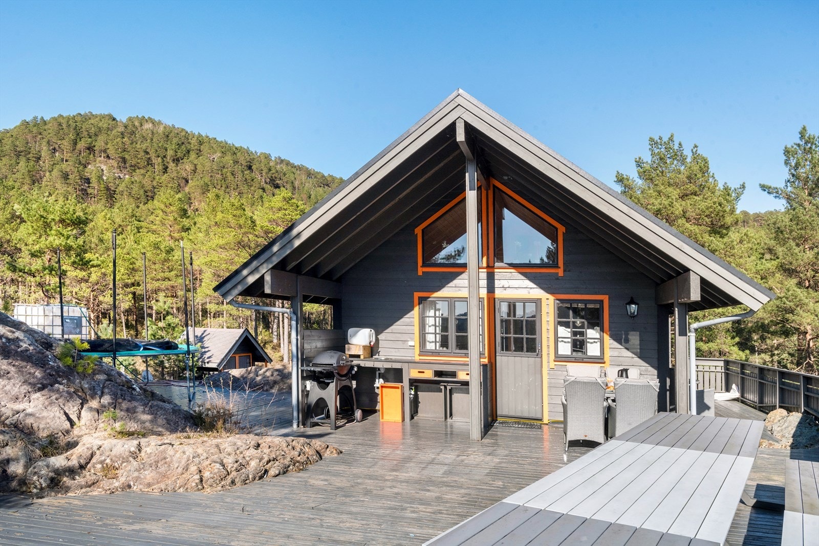 Deler av terrassen ved stue/kjøkken er overbygget og er utstyrt med utvendig stikkontakt og utekjøkken. Fra gassanlegget ved inngangspartiet er det trekt rør til utegrillen. Galleribilde