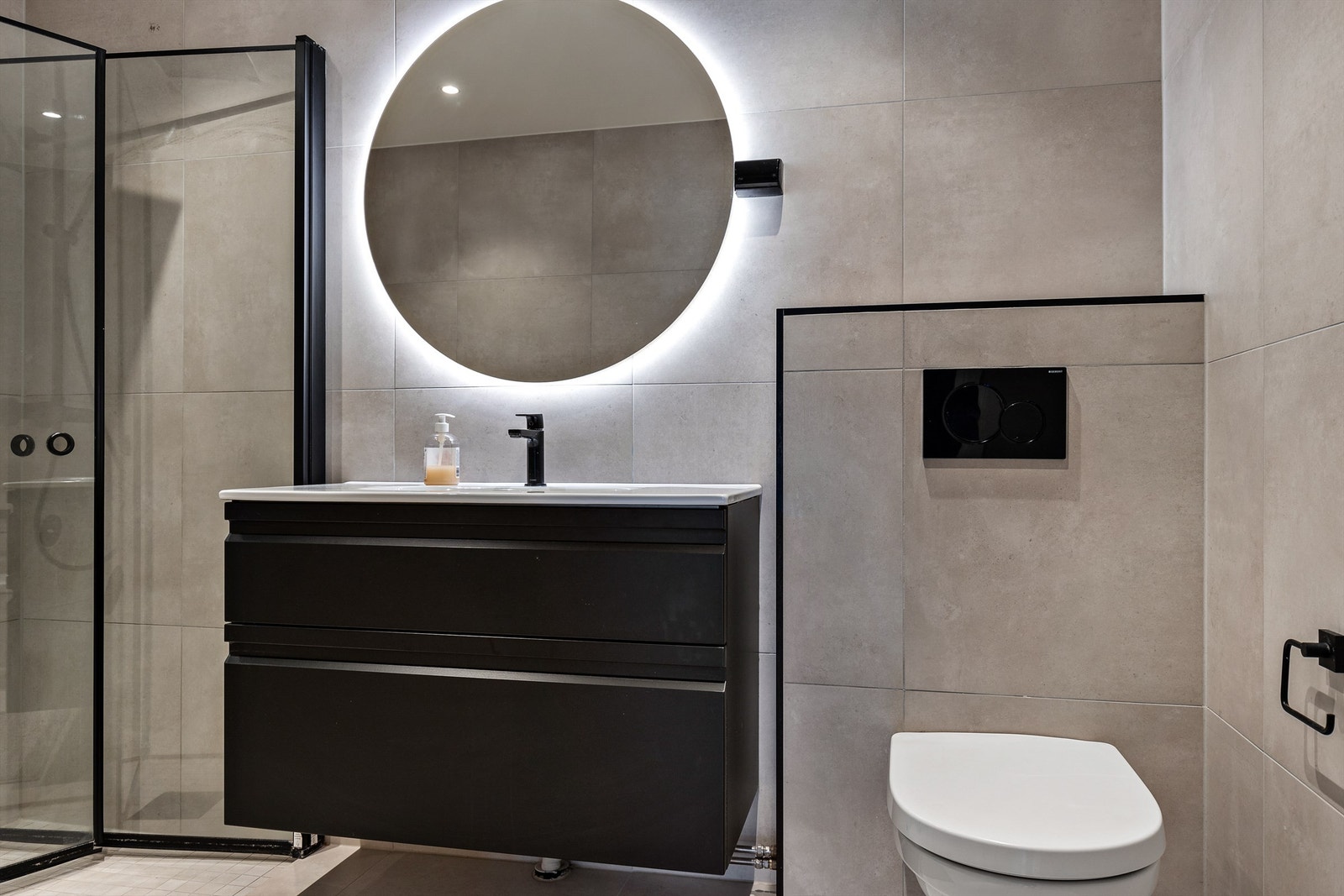 Badet i boligen er elegant flislagt på gulv og vegger med elektrisk gulvvarme. Galleribilde