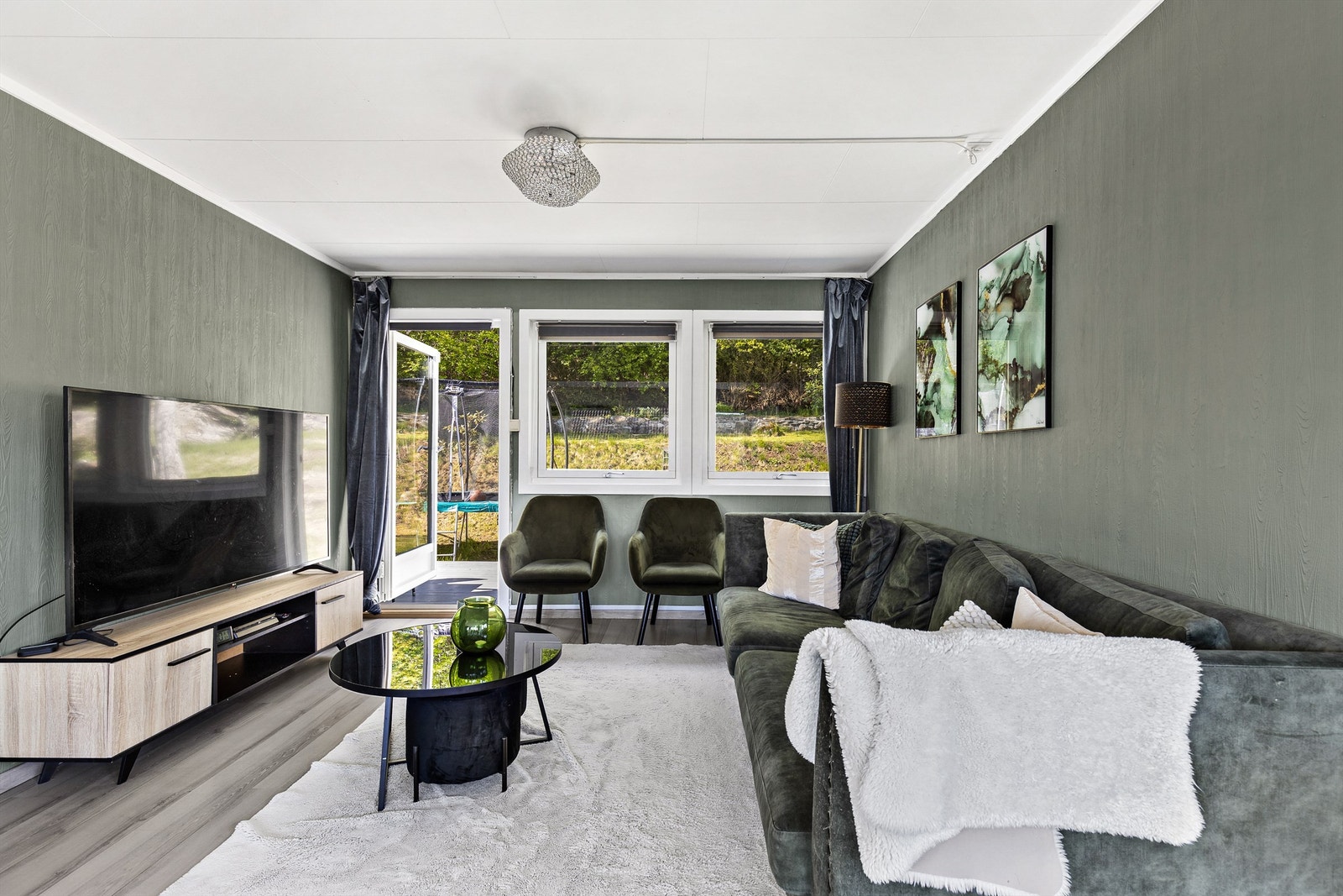 Stuen er av god størrelse med plass til sofa, salongbord og TV-seksjon. Her er det utgang til en stor terrasse med hage. Galleribilde