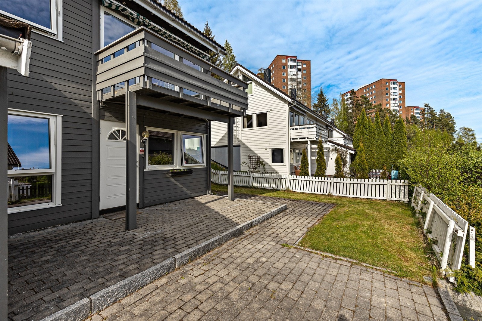 Inngangspartiet er pent opparbeidet med inngjerdet hage og brostein. Galleribilde