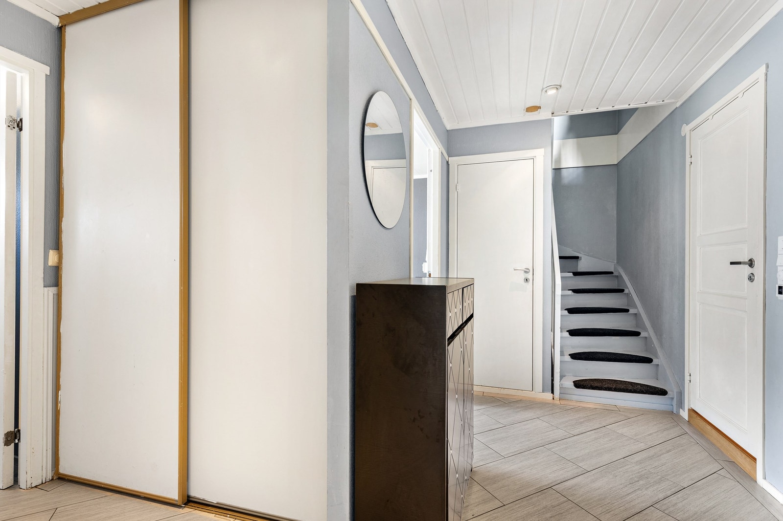 Velkommen inn! Boligens entré er av god størrelse og gir et godt førsteinntrykk. Her kan man henge fra seg yttertøy i en romslig skyvedørsgarderobe. Galleribilde