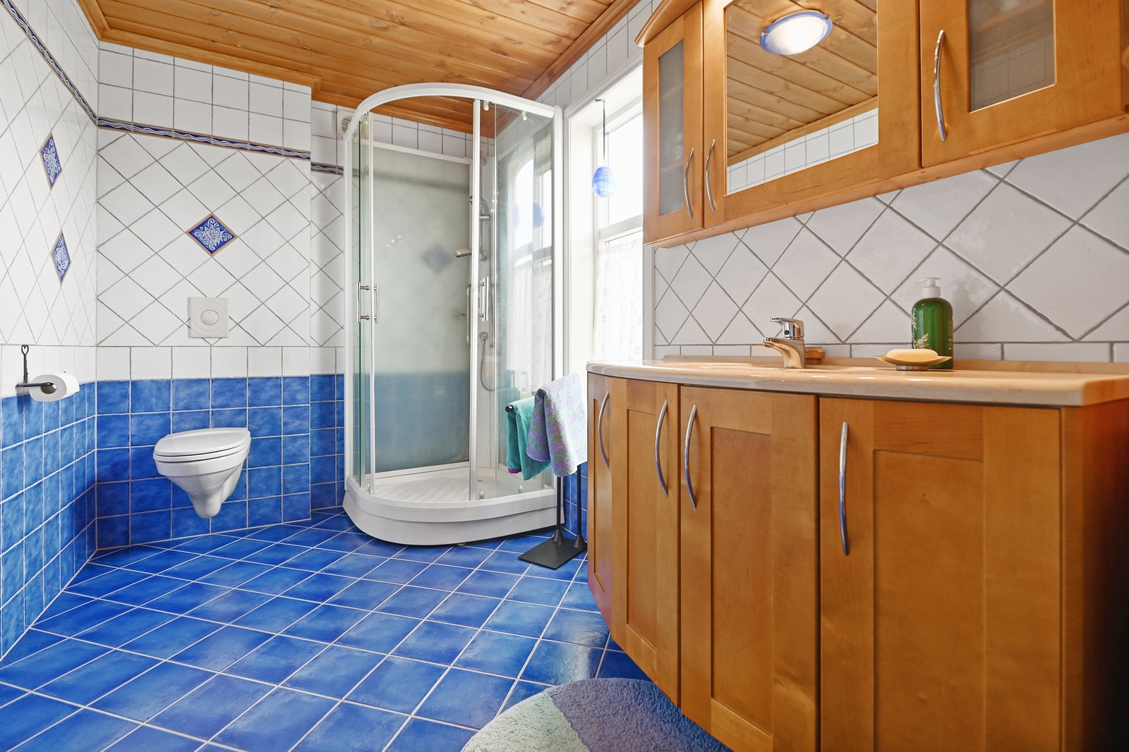 Her er det en stor og praktisk baderomsinnredning, dusjkabinett og vegghengt toalett. Galleribilde