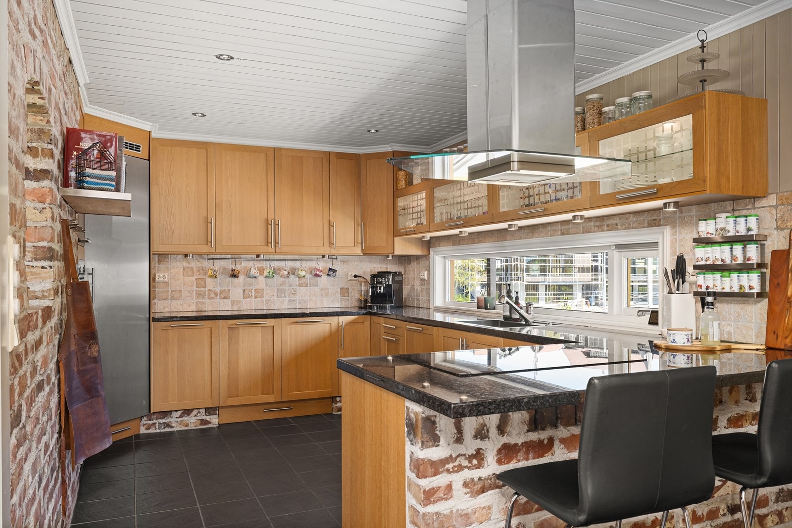 Kjøkkenet har profilerte fronter og benkeplate i stein. Galleribilde