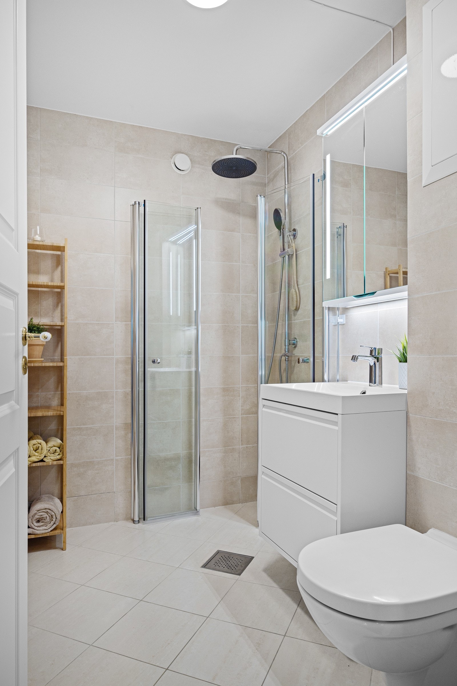 - Bad 1 med dusjnisje med innfellbare dusjvegger, vegghengt toalett, servant med skap og speilskap med lys - Galleribilde