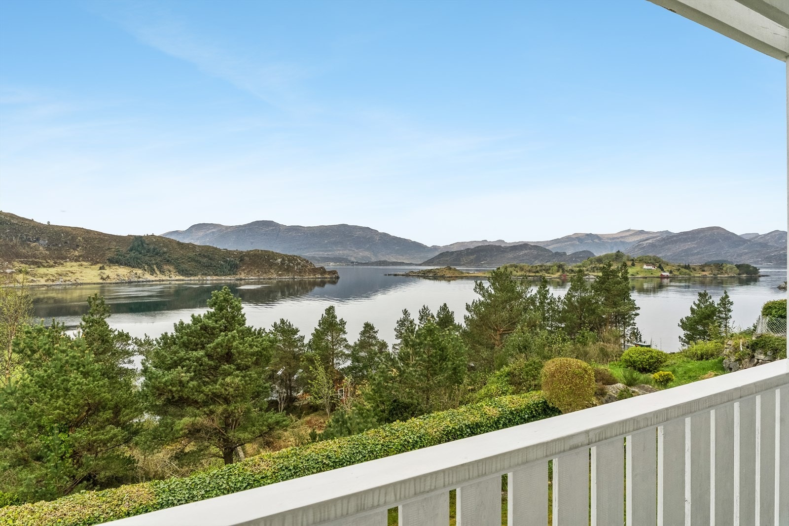 Frå stova har ein direkte utgang til sørvendt veranda som strekk seg langs store delar av bustaden. Her kan ein nyte utsynet over det vakre fjordlandskapet. Galleribilde