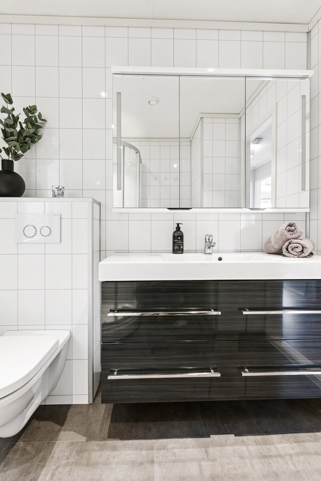 Badet er innreda med vegghengt toalett, dusjkabinett og innreiing med heildekkande servant samt god lagringsplass i skuffer og speilskap. Galleribilde