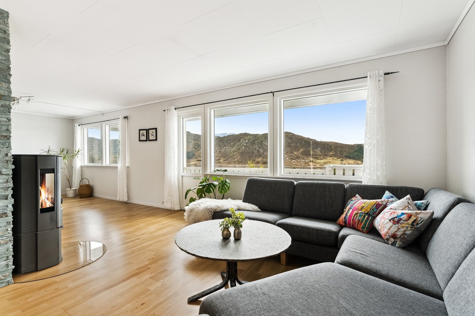 Velkomen inn! Stova er romsleg og vinkelforma, med store vindaugsflater som tek naturen inn i opphaldsrommet, og gjev rikelig med lys. Galleribilde