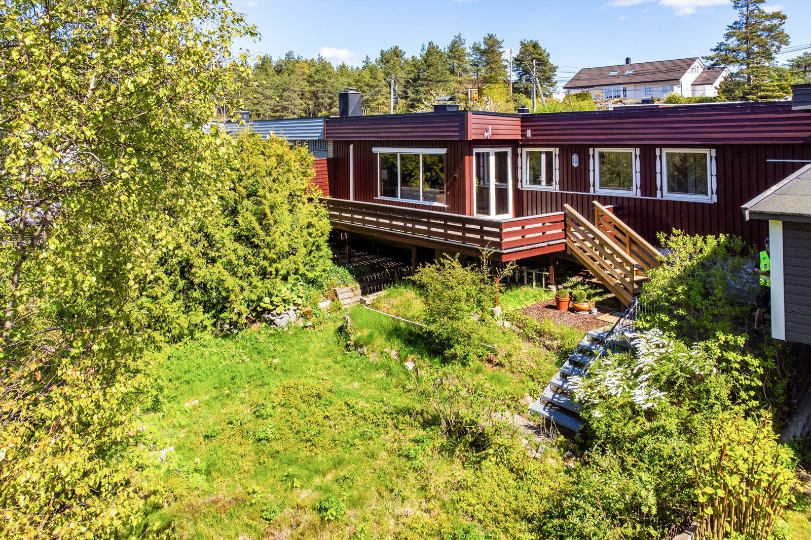 Vestsiden av tomtens 434 kvm. er i stor grad naturlig terreng, men solfylt og har flere muligheter - kanskje en kjøkkenhage? Galleribilde