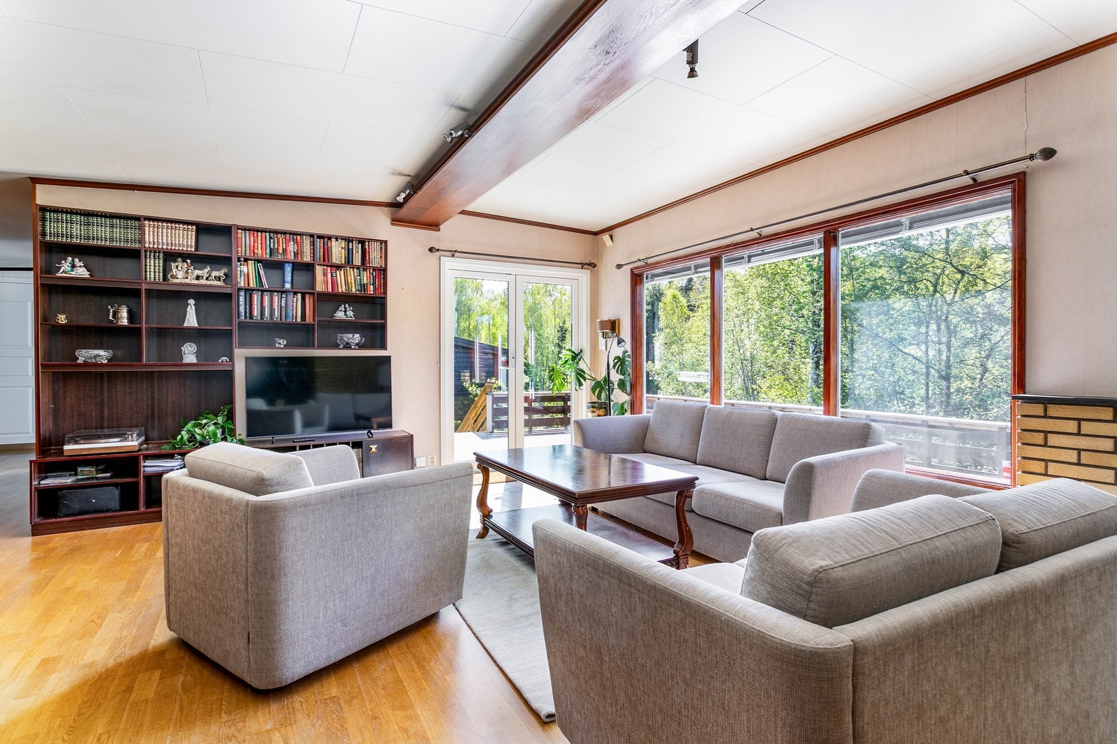 Terrassedøren og vindusrekken fyller stuen med både solstråler og naturlig lys. Galleribilde