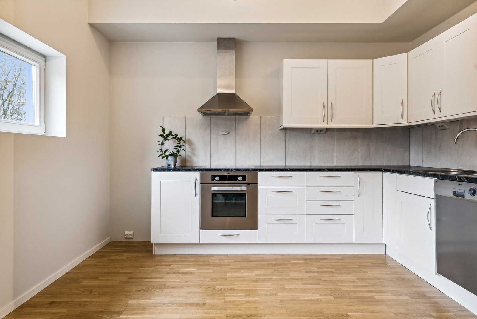 Kjøkkenet har en tidløs innredning - Praktisk utformet med en naturlig sone for spisestue Galleribilde