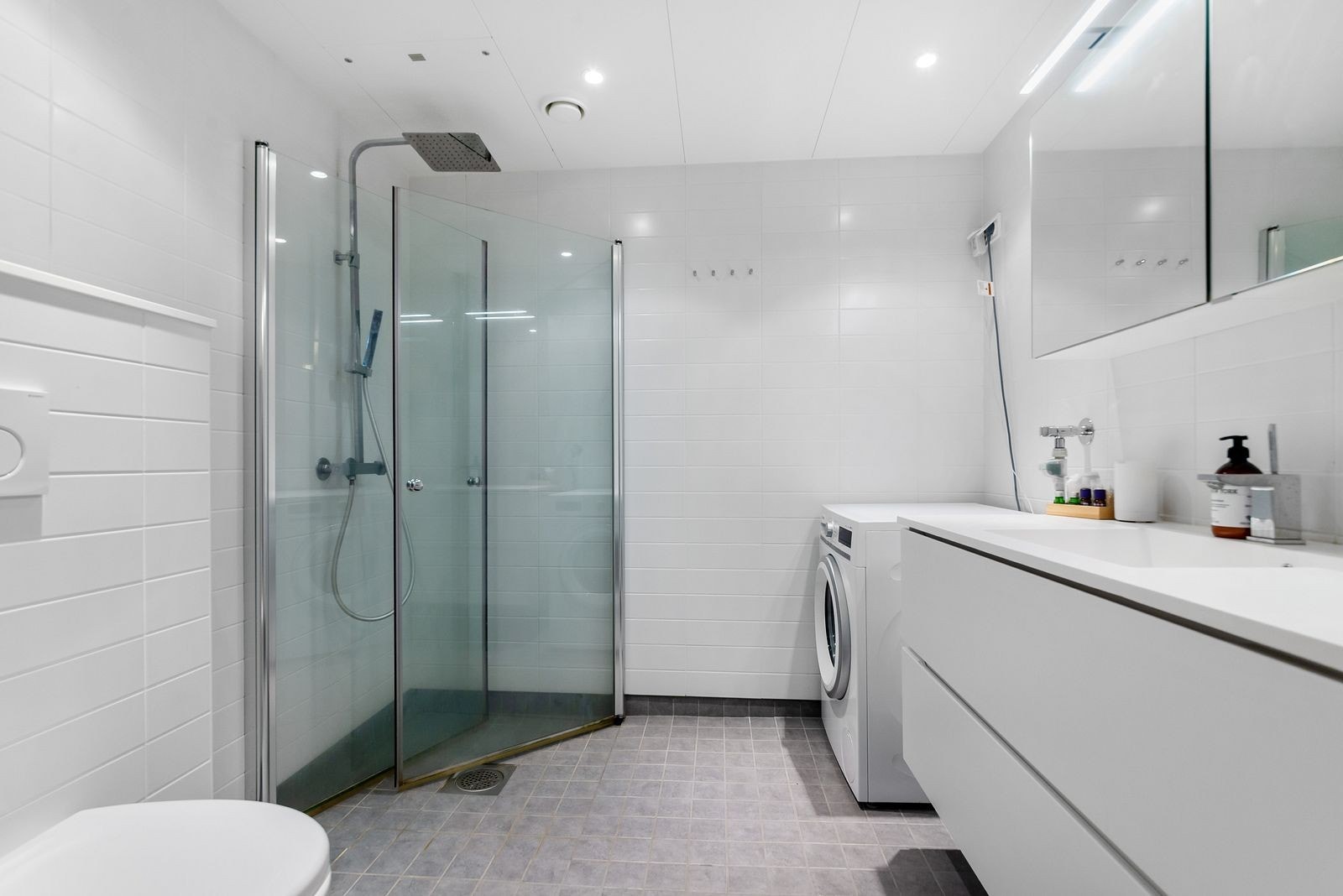 Baderom med vaskemaskin og varmakabler Galleribilde