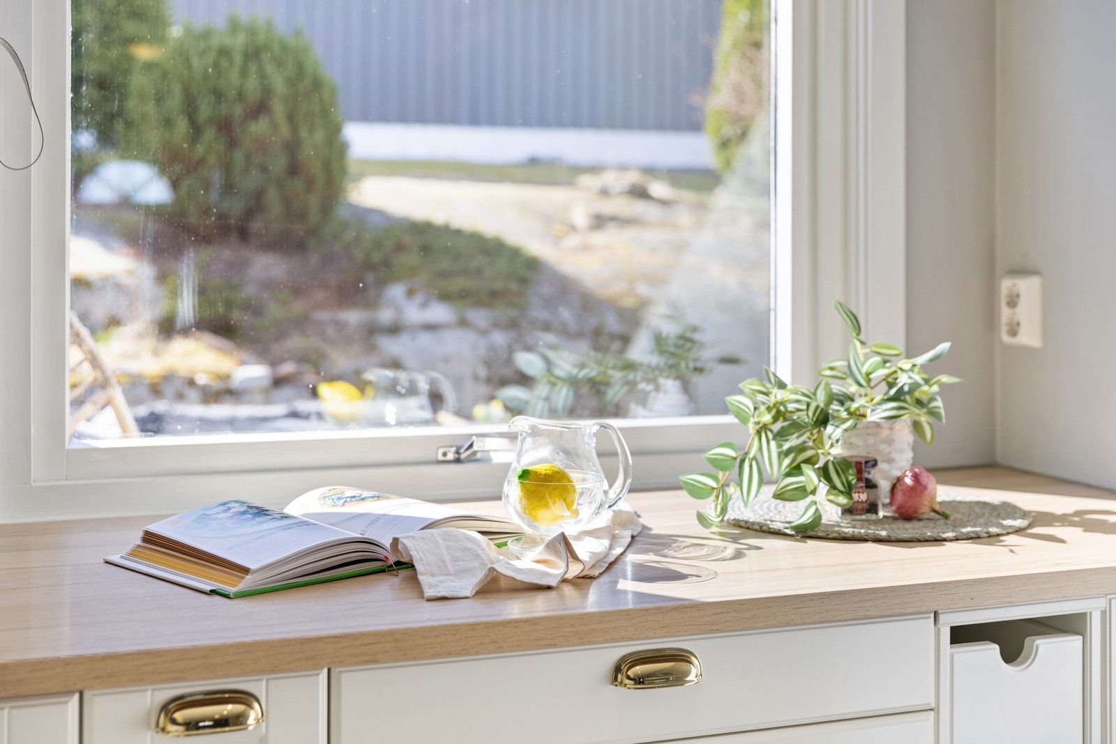 Det er praktisk belysning under overskap og det er fliser på vegg mellom overskap og kjøkkenbenk som gir et stilfullt preg. Galleribilde