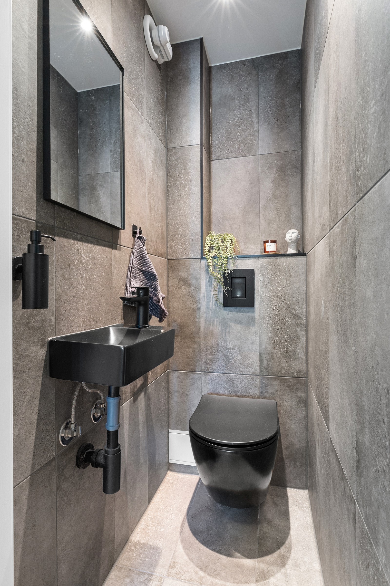 Toalettrommet fra 2023 og er innredet med liten servant, speil på vegg over servant og et vegghengt toalett. Galleribilde