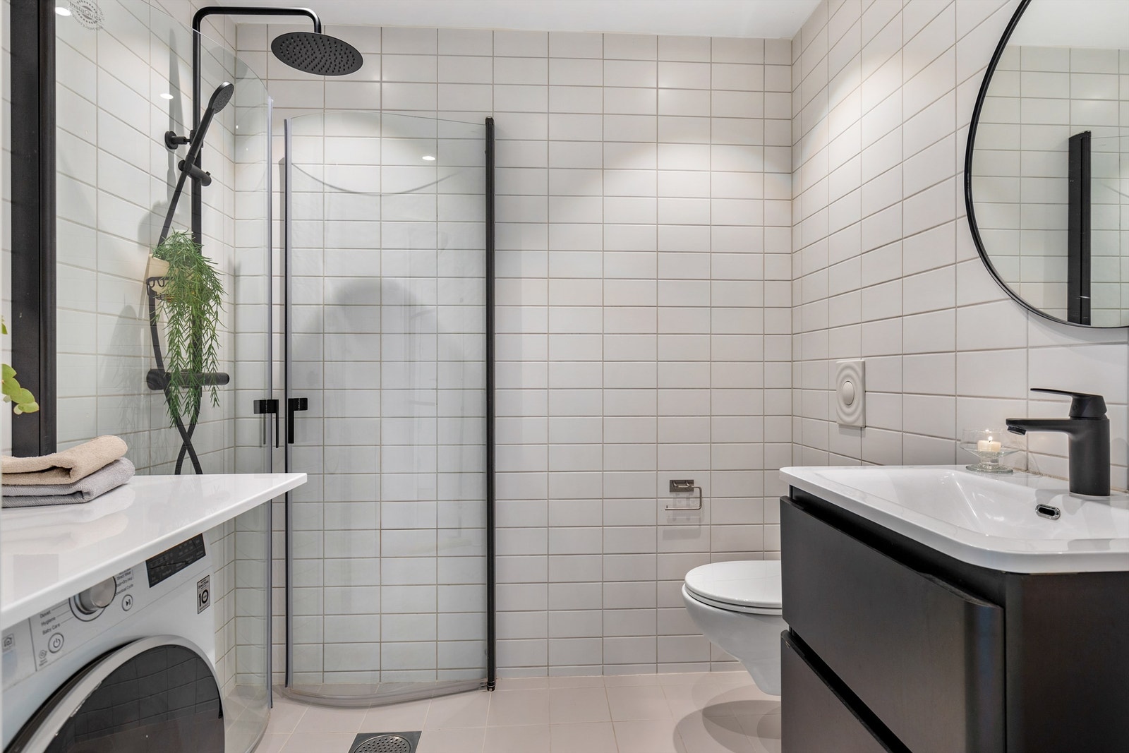 Badet er pent flislagt på gulv og vegger, og har lekre detaljer i sort som skaper et luksuriøst og stilrent uttrykk. Galleribilde