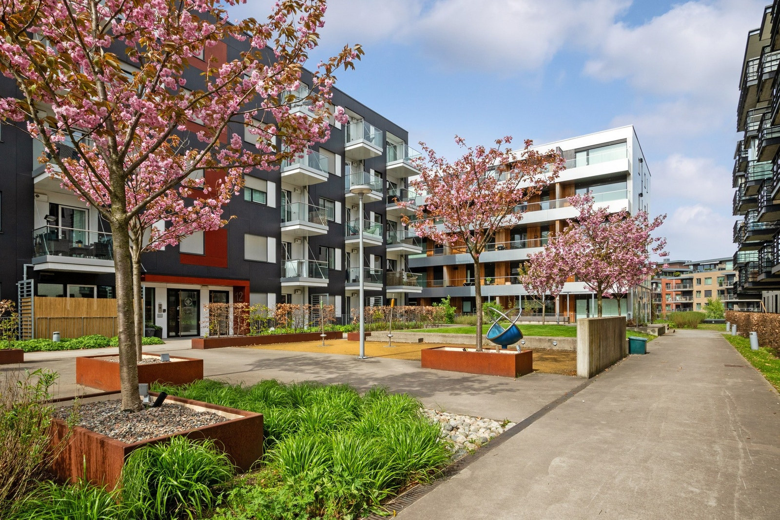 Felleseiendommen er parkmessig opparbeidet med plenareal, prydbusker og trær. Galleribilde