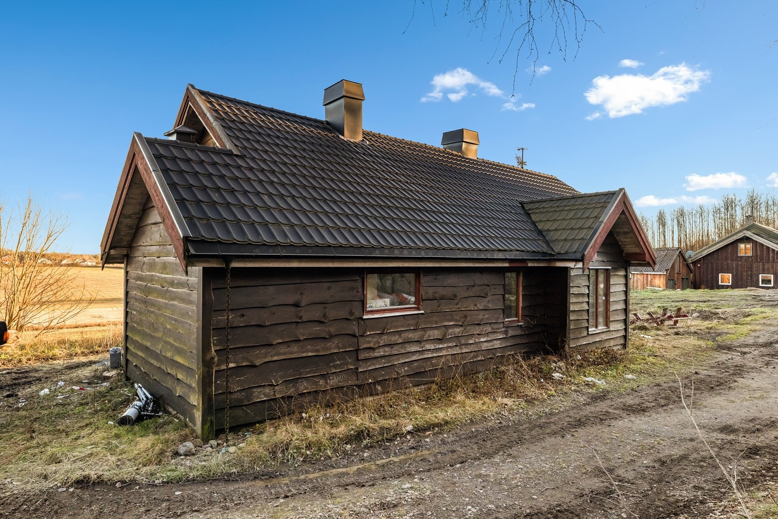 Veggene har tømmerkonstruksjon og noe bindingsverk. Fasade/kledning har liggende
villmarkspanel. Galleribilde