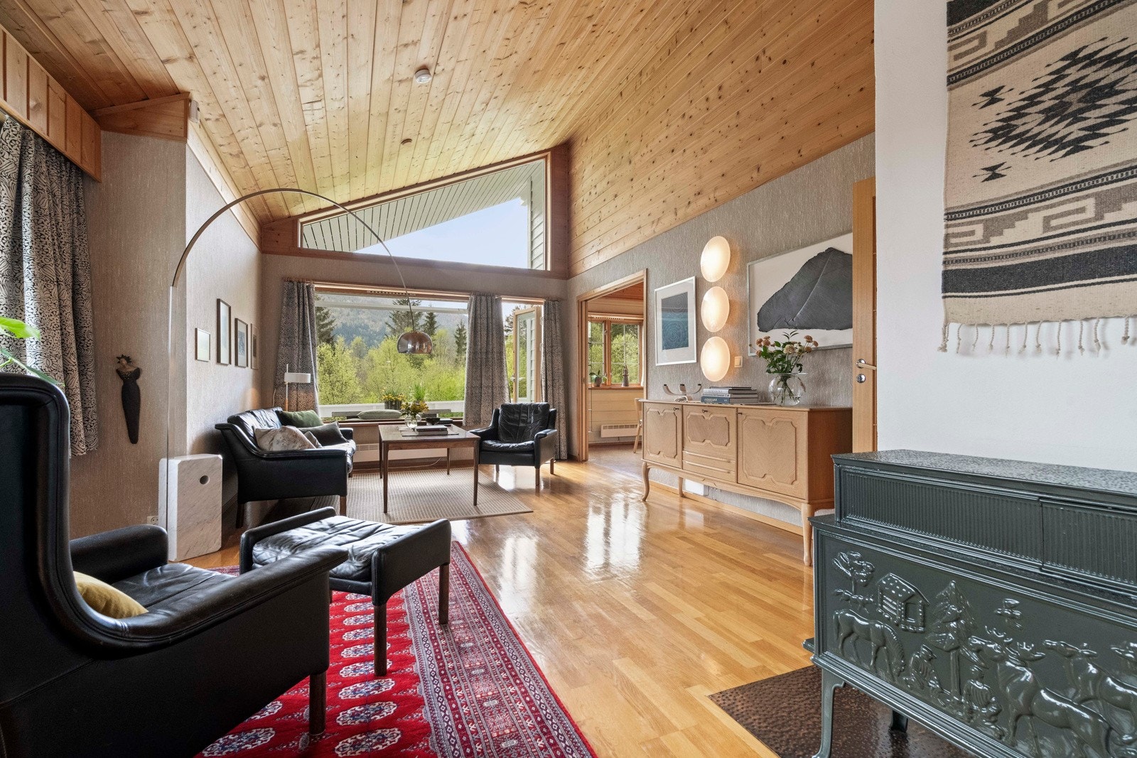 Stue på hovedplan har mønt himling og store vindu mot sør - det er også adkomst ut til sørvendt veranda Galleribilde