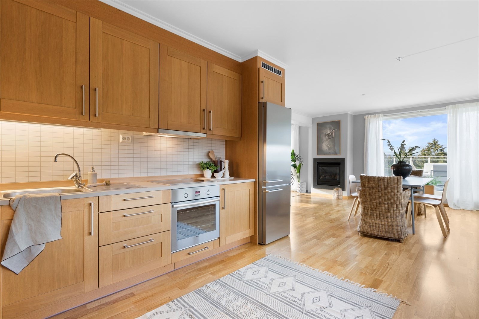 Kjøkkenet har en moderne åpen løsning mot stuen og har parkettgulv, tapetserte vegger og malte plater i himlingen. Eikekjøkkenet er fra 2007/2008 og alt av hvitevarer vil medfølge. Galleribilde