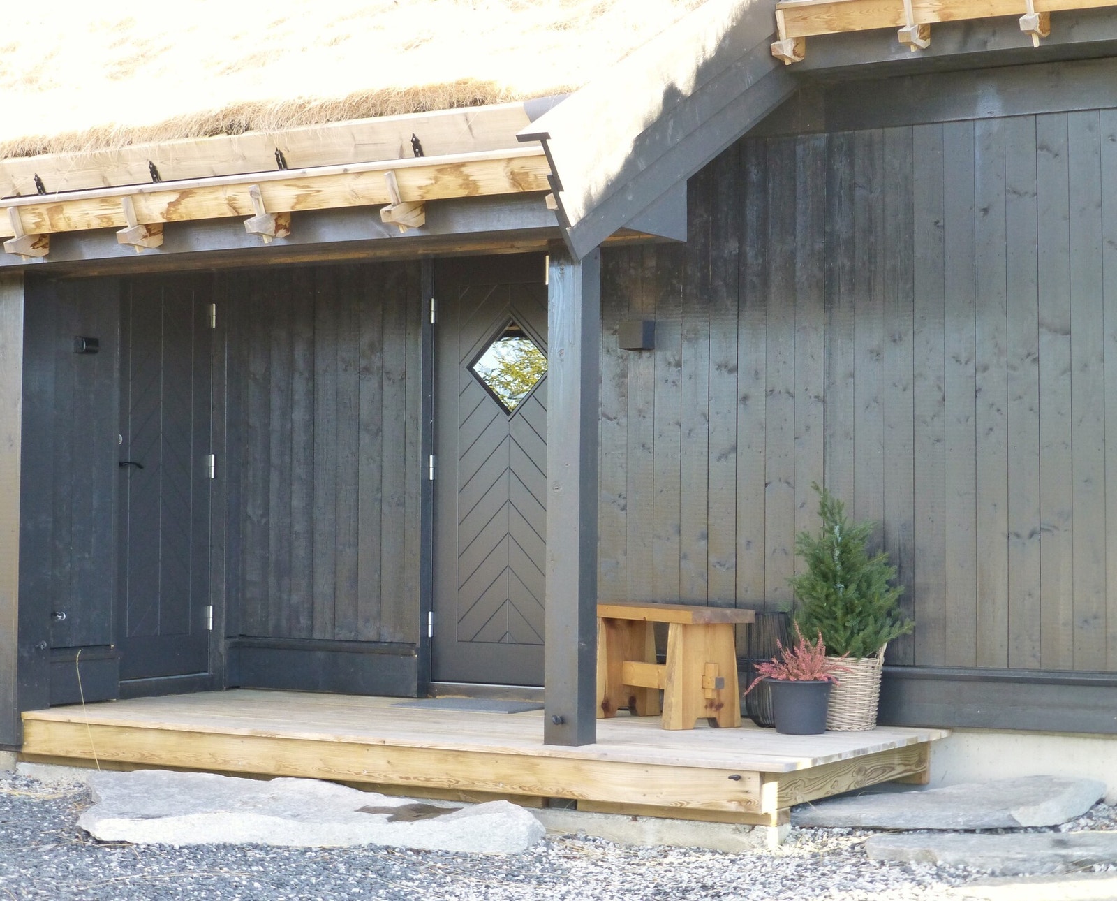 Overbygget inngangsparti med plass til sittebenk. Galleribilde