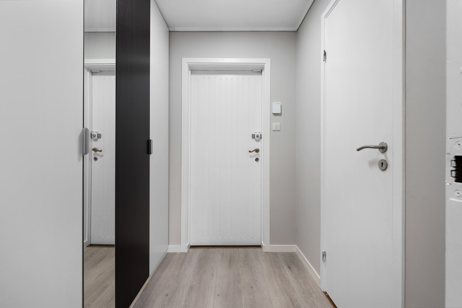 Inngangsparti med lyst gulv og vegger, samt garderobeskap. Galleribilde
