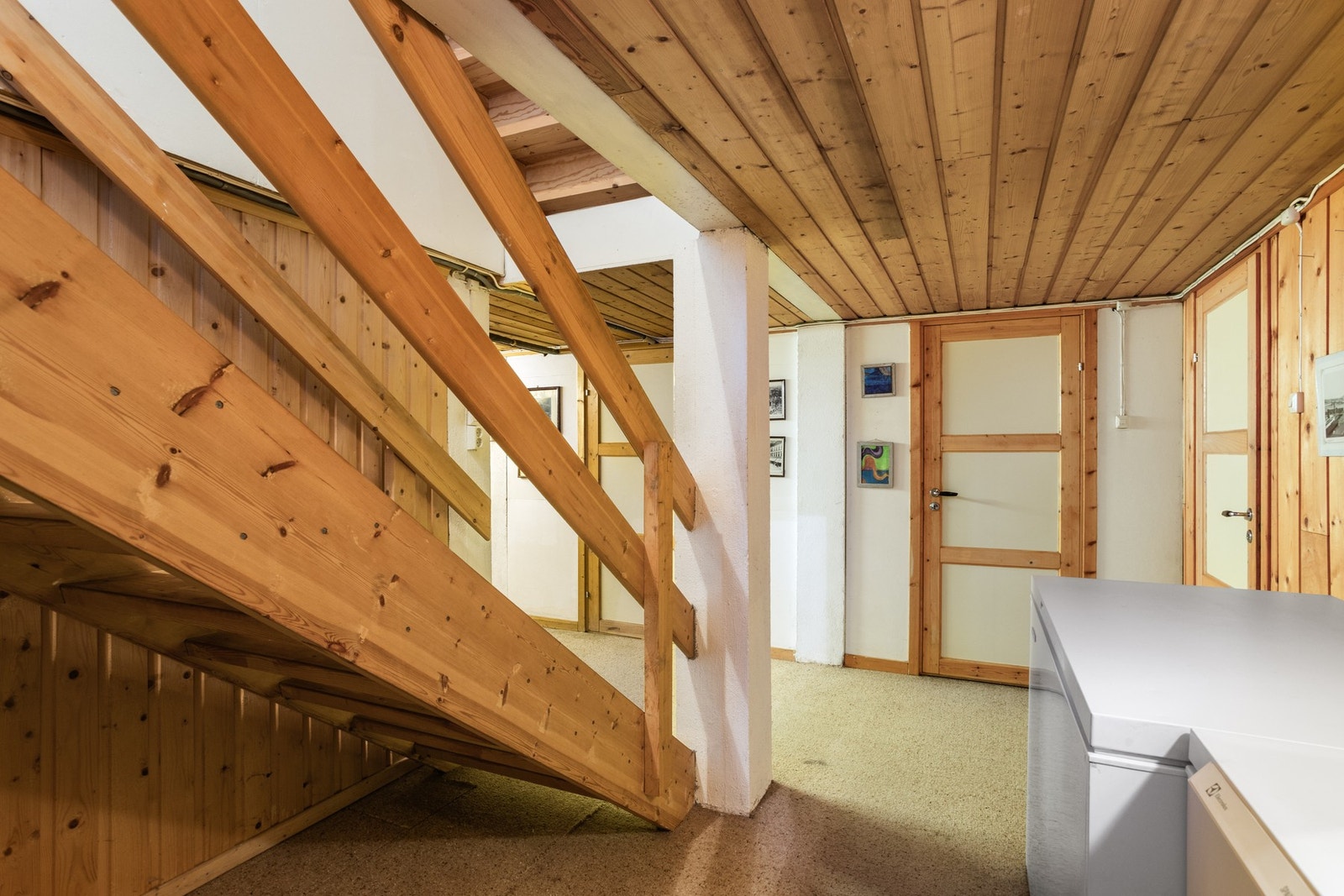 Romslig kjellerhall med gjennomgående bruk av trepanel og naturlige materialer. Galleribilde