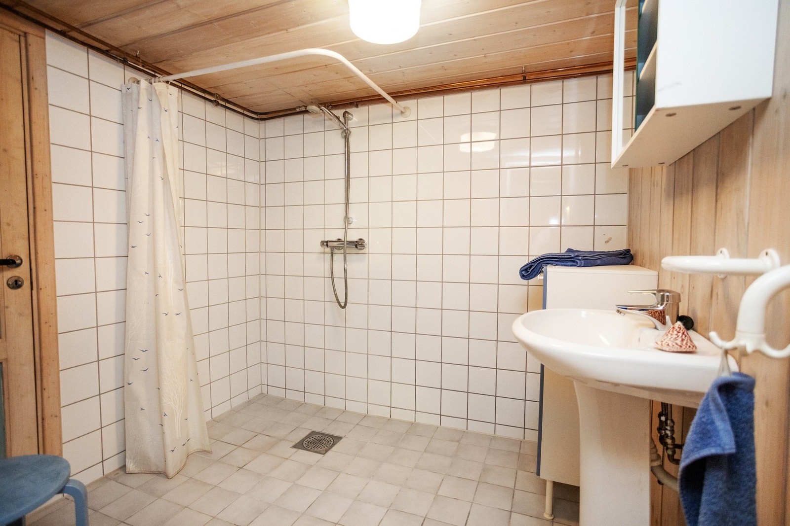 Praktisk baderom med varmekabler utstyrt med dusjsone og servant. Galleribilde